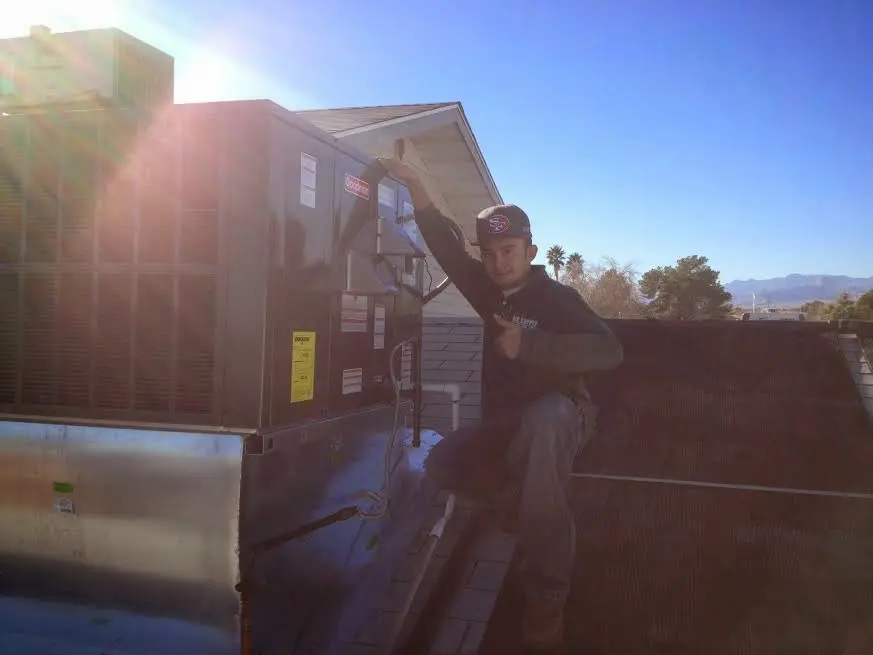 HVAC technician performing Heat Pump Repair on a rooftop unit in Little Rock